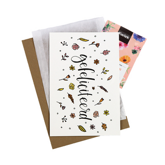 Bloemenzaden met kaart 'Gefeliciteerd' verpakt in pergamijn zakje